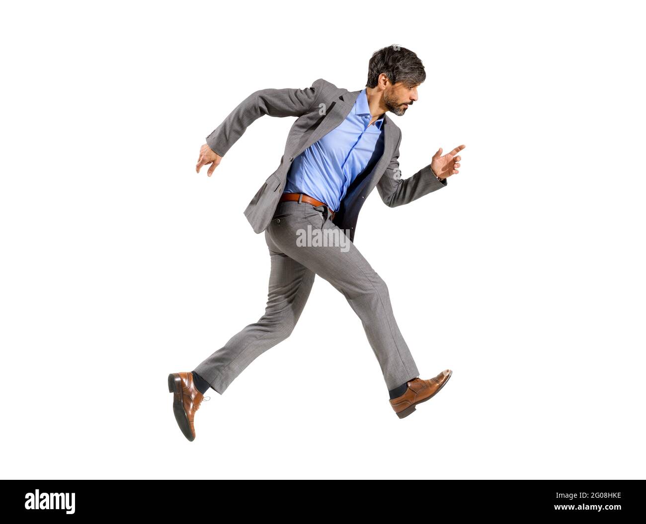 Ein Geschäftsmann in einem eleganten Anzug, der sehr schnell in Eile läuft und einen zielstrebig fokussierten Ausdruck auf einem weißen Hintergrund ausdrückt Stockfoto