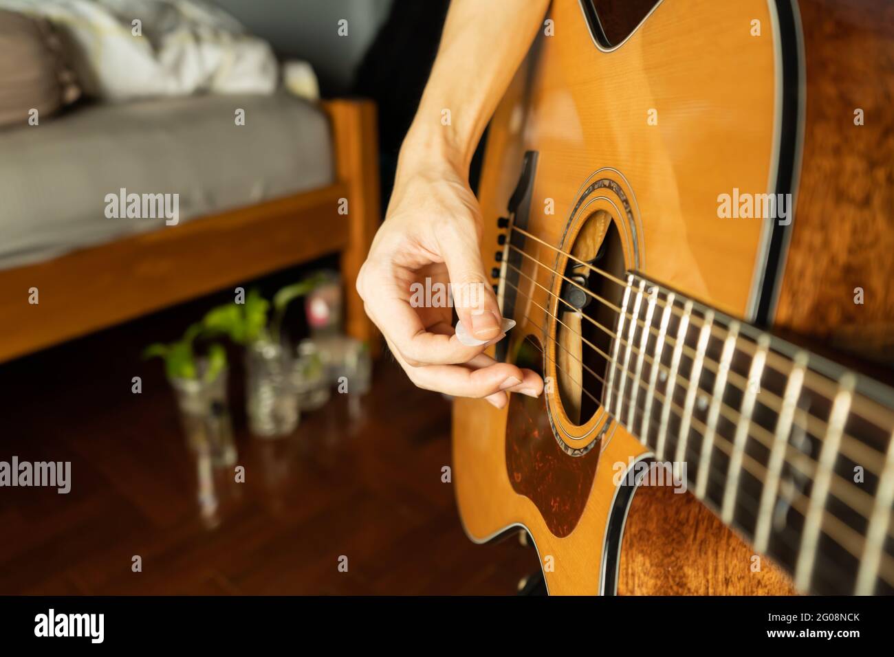 Akustische Gitarre im Schlafzimmer spielen Stockfoto