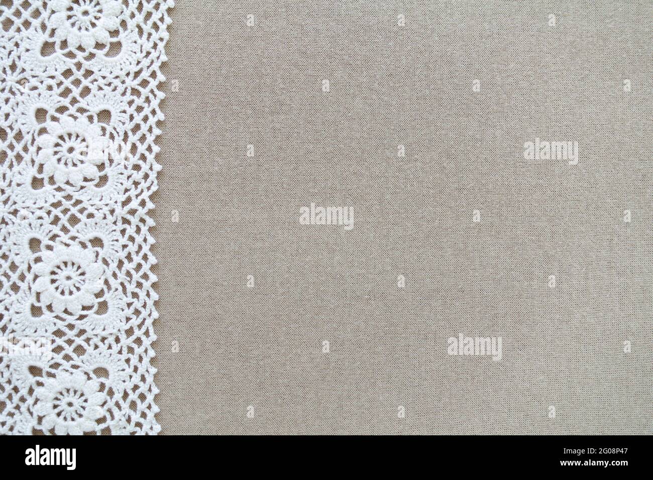 Weißes handgefertigtes gehäkeltes handgefertigtes Muster auf beigem Hintergrund, Kopierraum. Stockfoto