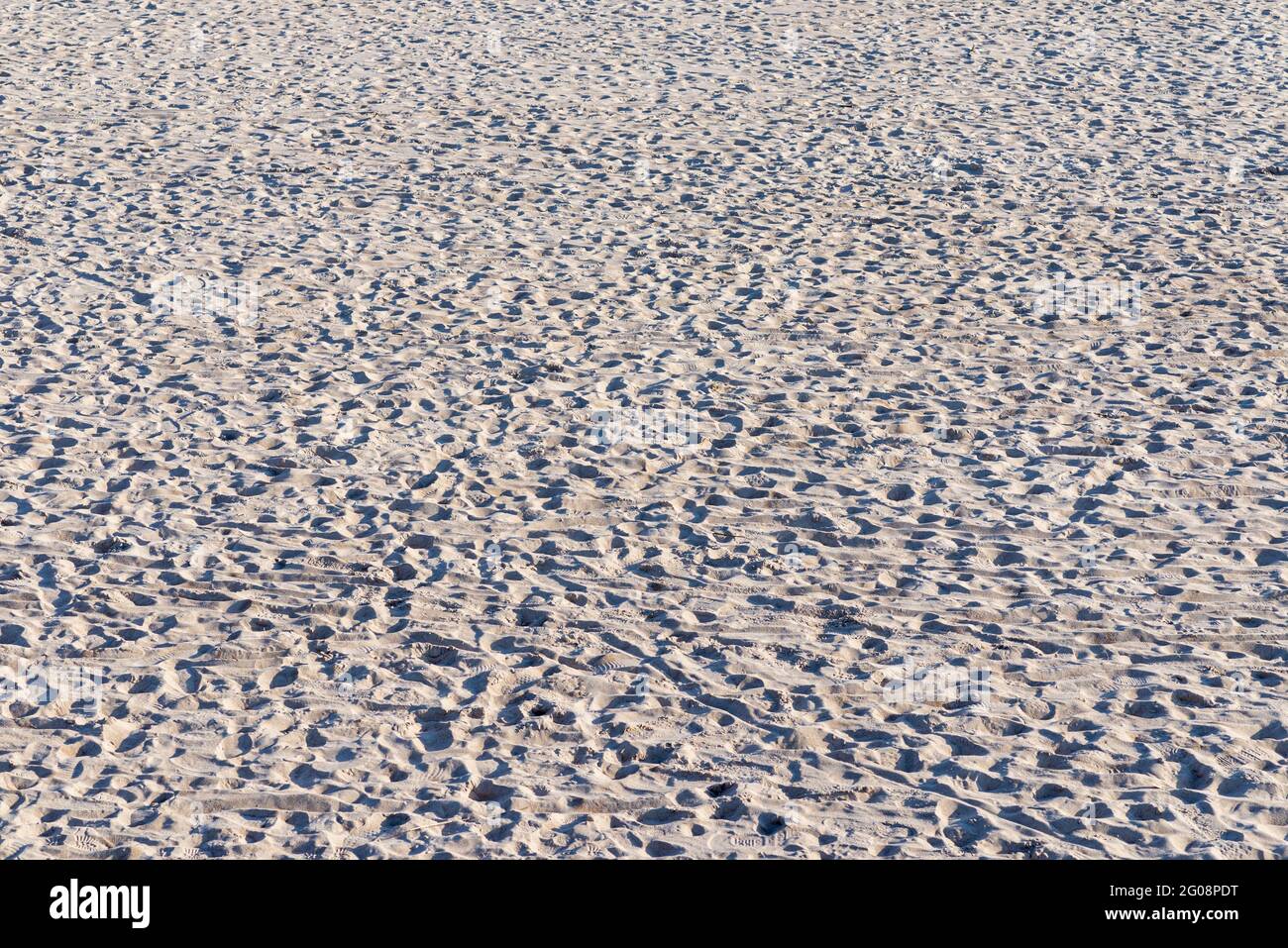 Klare Textur von beigefarbenem Wellensand.Nahaufnahme des Sandtextur-Hintergrunds am Strand. Stockfoto