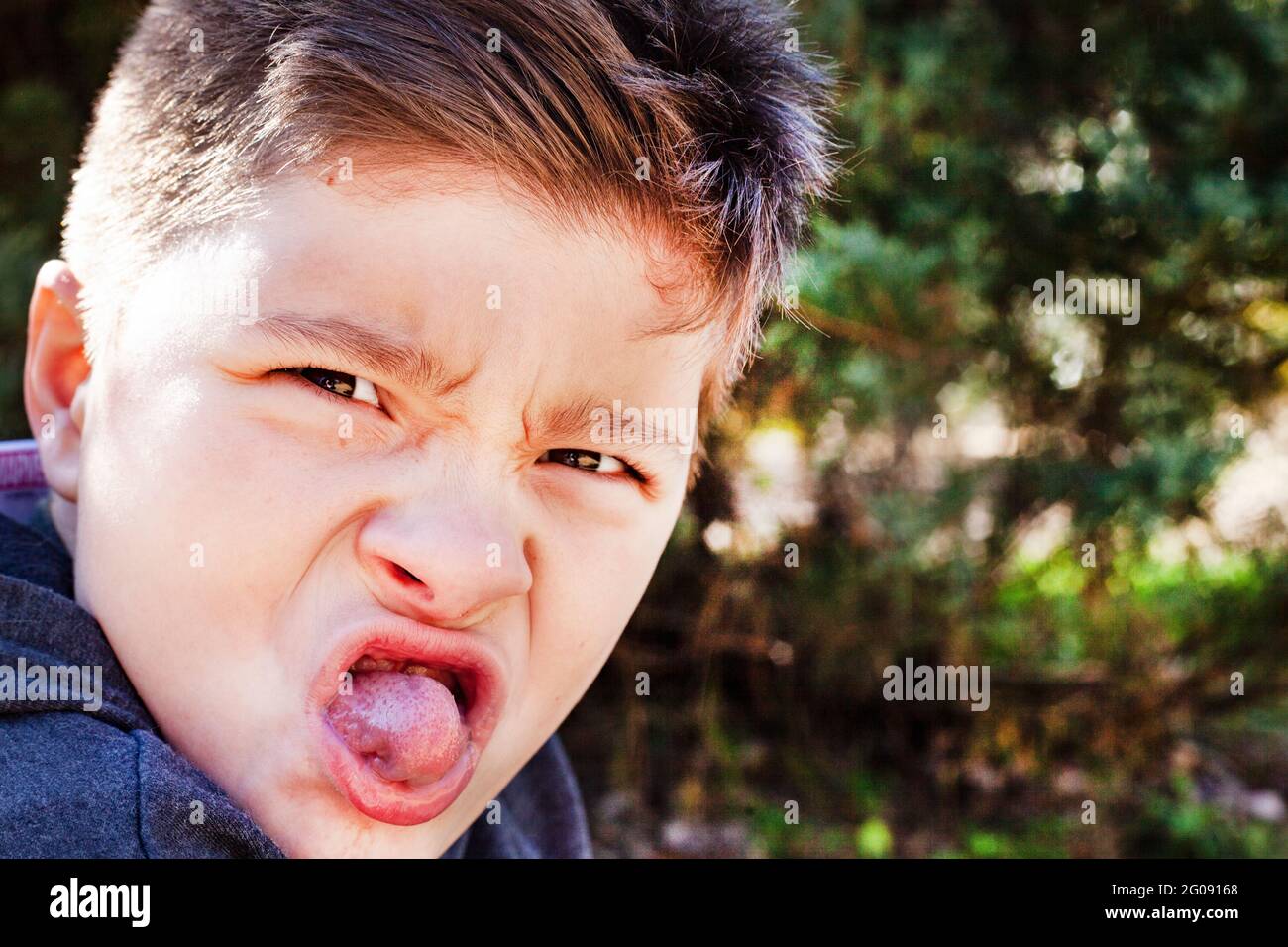 Junge, der ein Gesicht im Park zieht Stockfoto