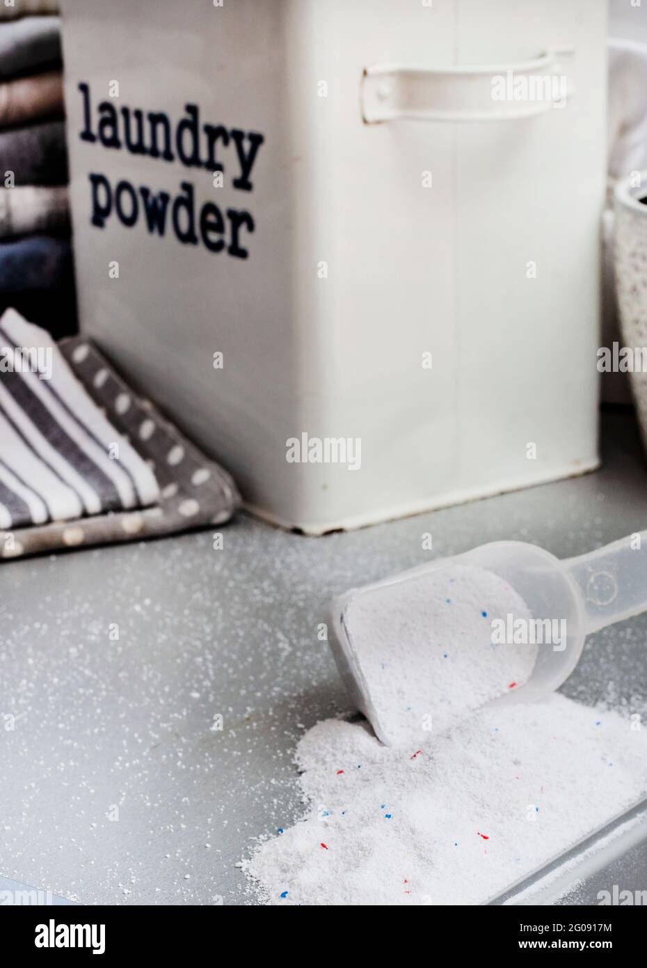 Waschpulver und Schaufel auf der Vorderseite der Waschmaschine Stockfoto