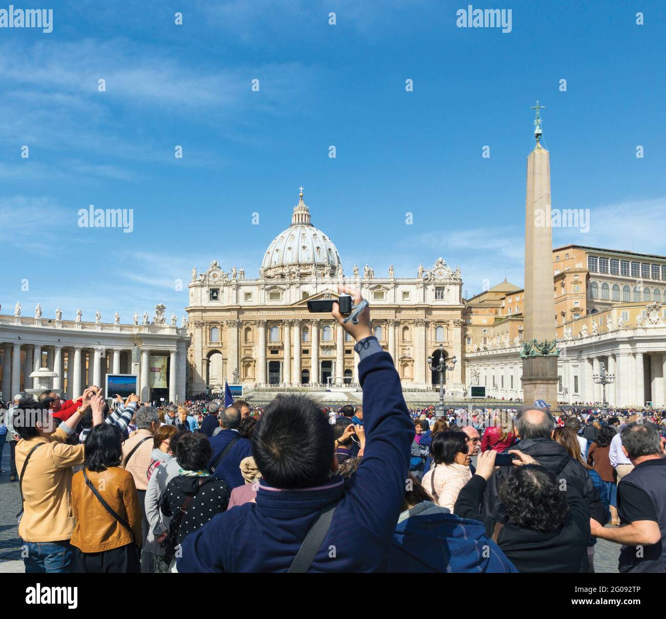 Rom, Italien. Petersdom auf einem überfüllten Petersplatz. Das historische Zentrum von Rom ist ein UNESCO-Weltkulturerbe. Stockfoto