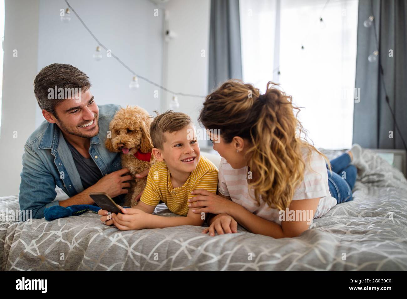 Glückliche junge freundliche Familie verbringen Spaß Zeiten zusammen und kuscheln Mit ihrem Haustier zu Hause Stockfoto