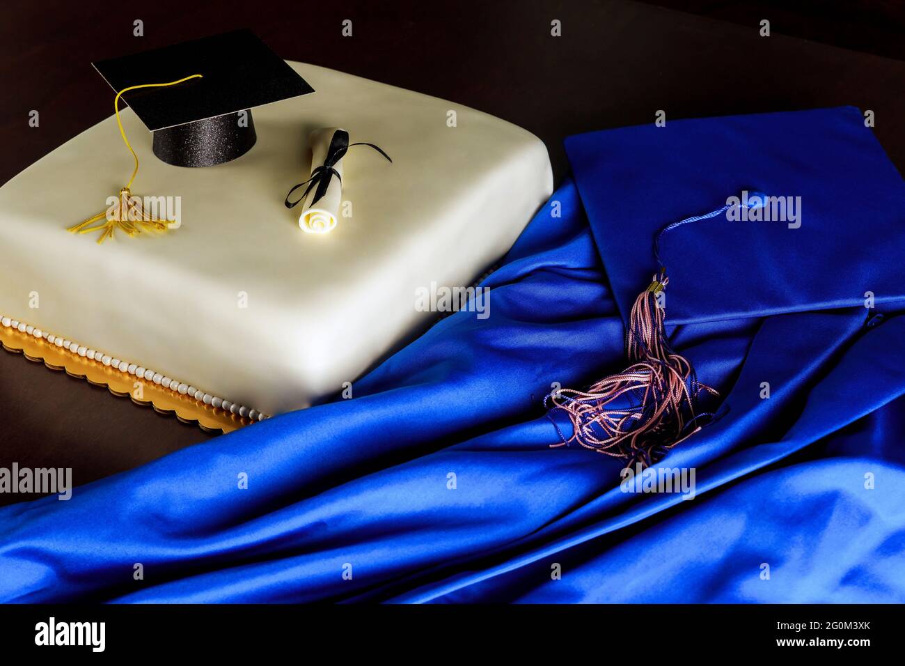 Kleid und Abschlusskappe mit Kuchen für Ende der Schule. Stockfoto