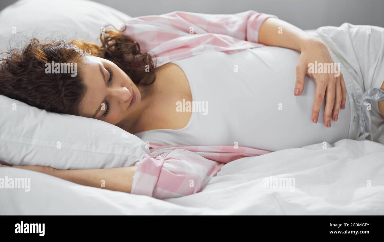 Junge, schwanger Frau schläft im Bett Stockfoto