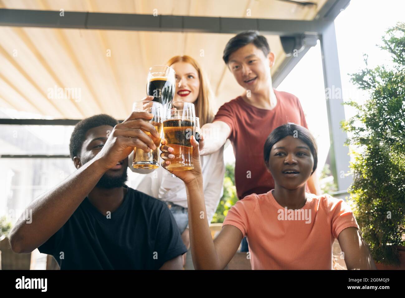 Junge Männer und Mädchen, Freunde treffen sich im Café, Pub. Konzept der Freundschaft, Freizeitbeschäftigung, Emotionen, Stockfoto