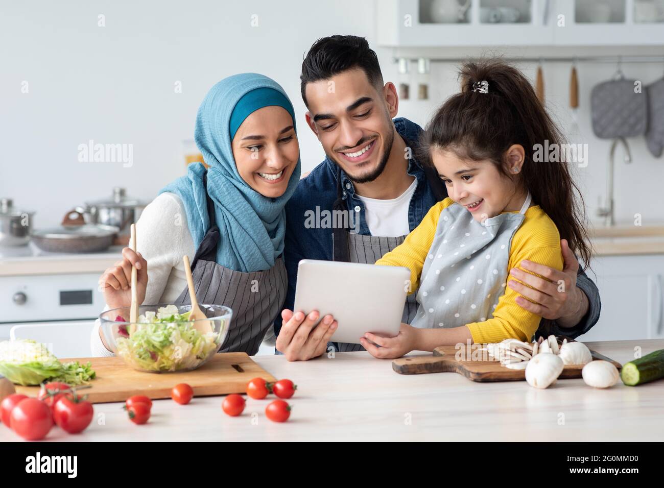 Happy Muslim Family Mit Digitalem Tablet Beim Gemeinsamen Kochen In Der  Küche Stockfotografie - Alamy