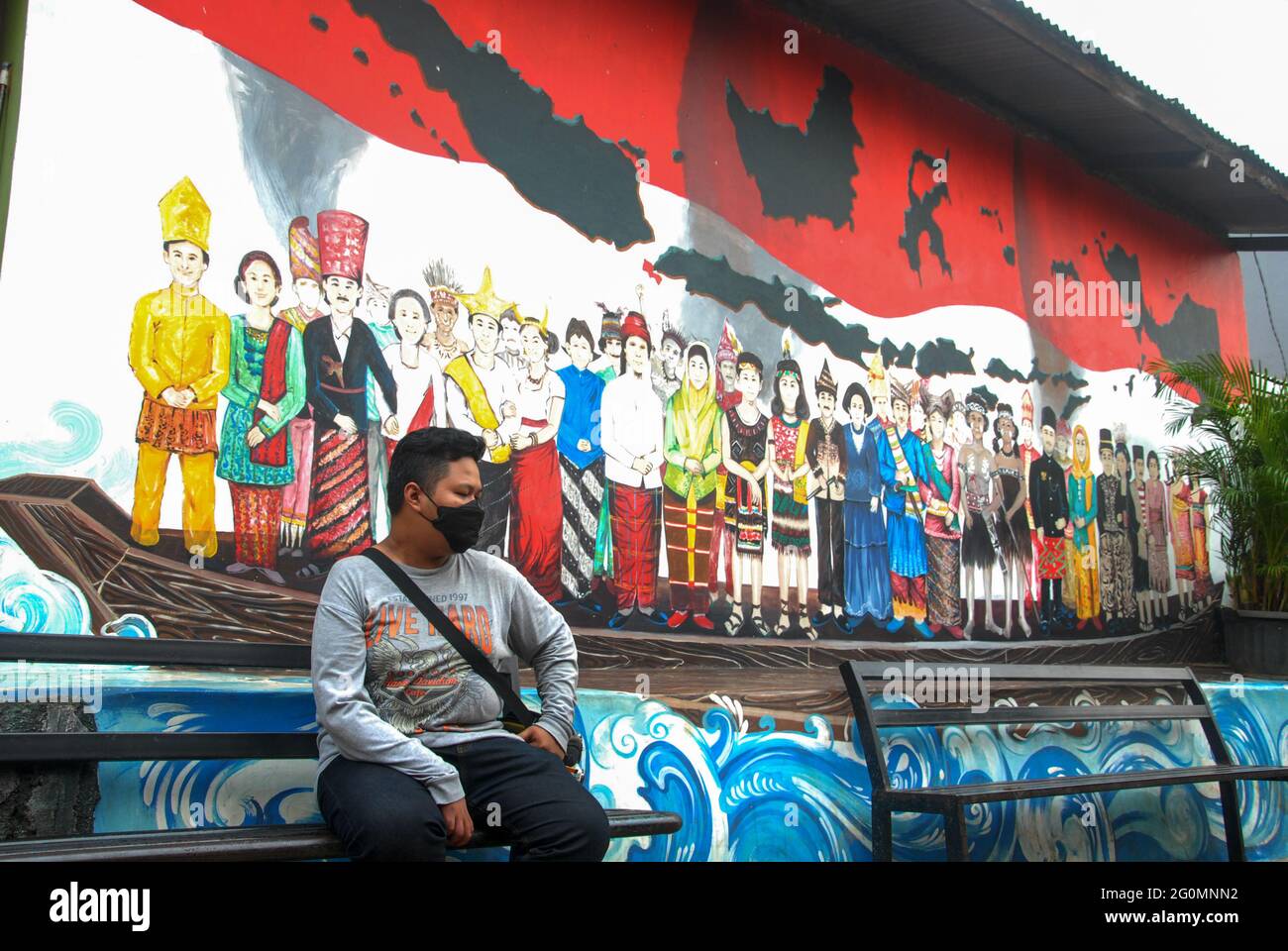 Indonesien. Juni 2021. Am Dienstag, den 1. Juni 2021, läuft eine Person hinter einem Wandgemälde über Pancasila im thematischen Dorf des Pancasila Terrace Village, Karang Tengah, Tangerang, Banten, Indonesien. Die Veranstaltung, die zum Gedenken an den Geburtstag von Pancasila stattfand, zielt darauf ab, Einblick und Wissen über die Werte von Pancasila zu geben. (Foto: Ahmad Soleh/Sipa USA) Quelle: SIPA USA/Alamy Live News Stockfoto