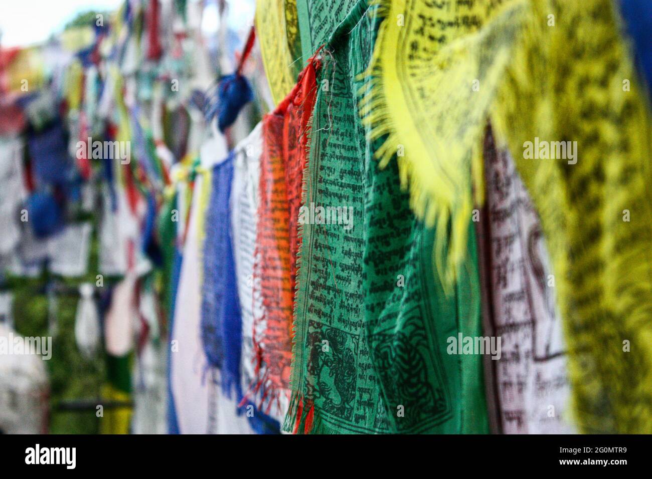 Selektive Fokusaufnahme der an Seilen hängenden buddhistischen Gebetsfahnen Stockfoto
