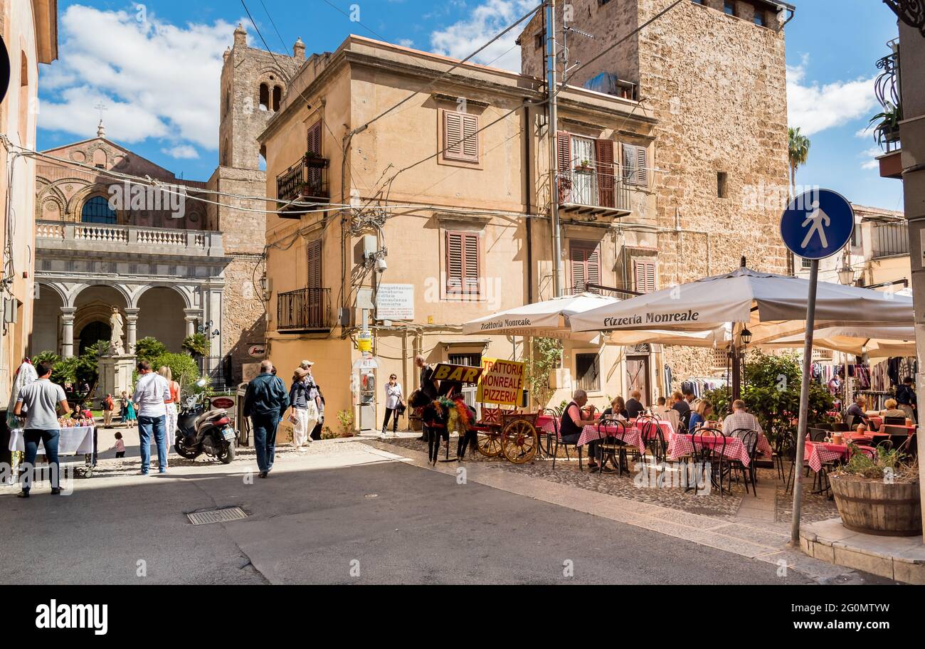 Monreale, Sizilien, Italien - 8. Oktober 2017: Die Menschen genießen die Straßenbar in einer engen Straße im historischen Zentrum von Monreale. Stockfoto