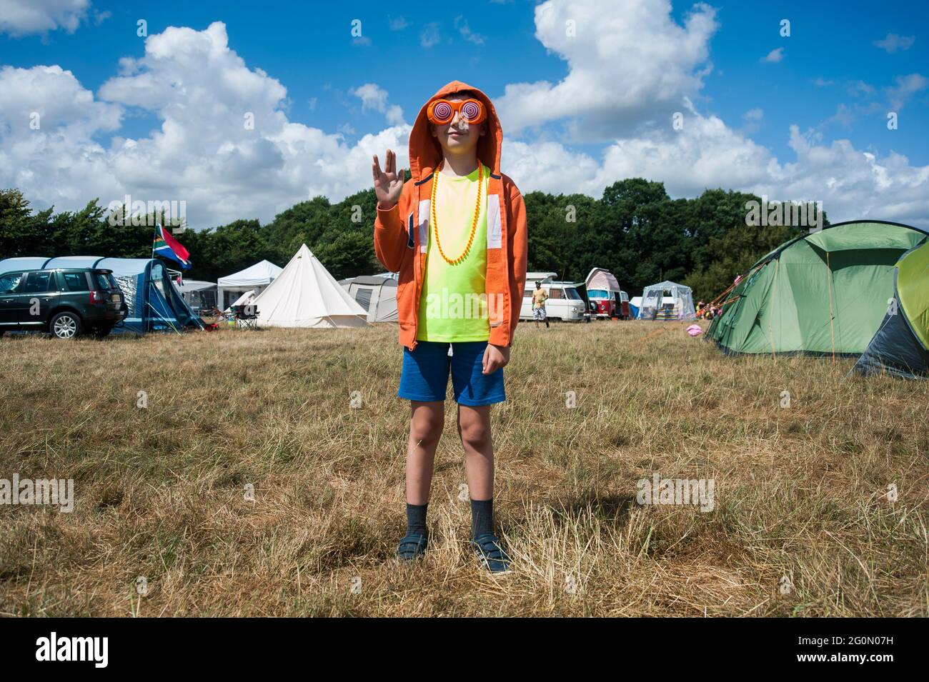 Ein kleiner Junge im Festkostüm mit Neon Stockfoto