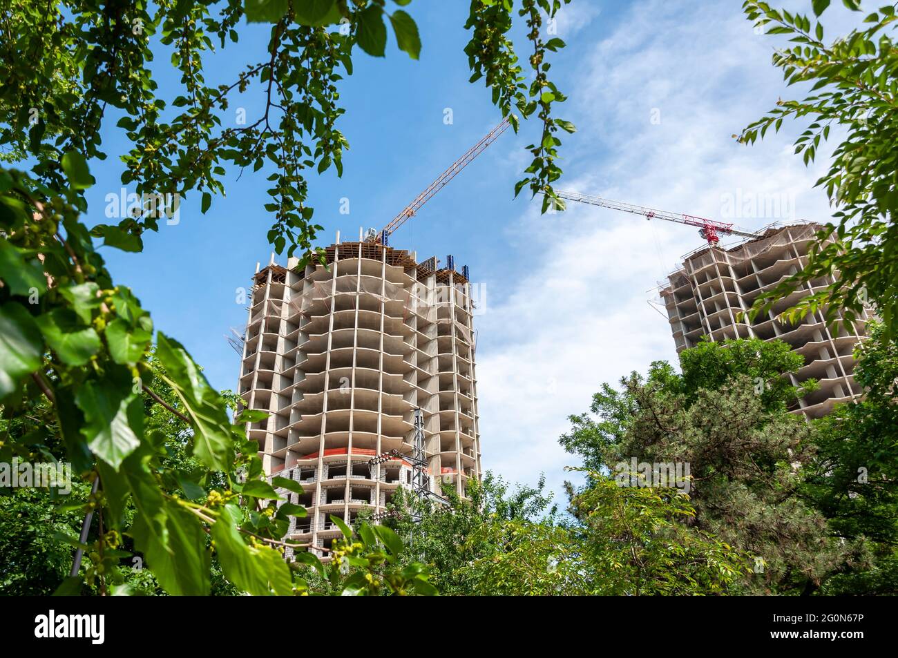 Baustelle am sonnigen Tag. Concrete Highrise Baustelle mit Turmdrehkran gegen blauen Himmel Stockfoto