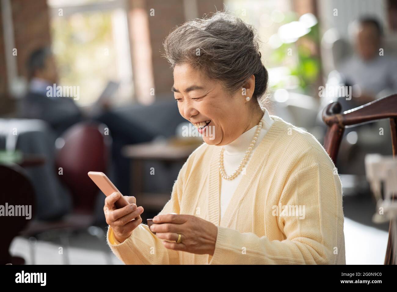 Glückliche alte Menschen nutzen Handys, um Videos zu sehen Stockfoto