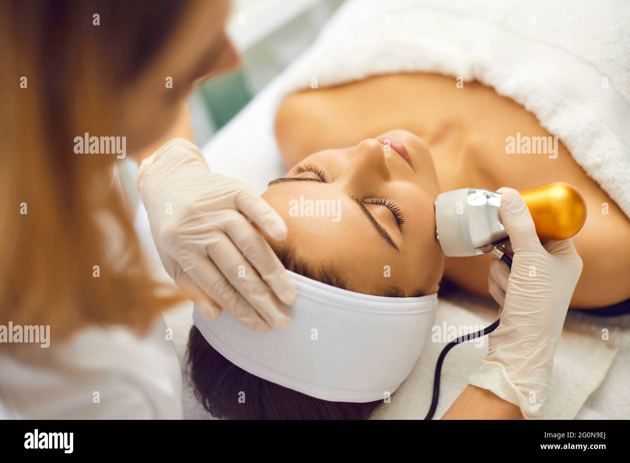 Hände des Kosmetologen, der die Lymphdrainage des Gesichts für die Frau im Spa-Salon macht Stockfoto