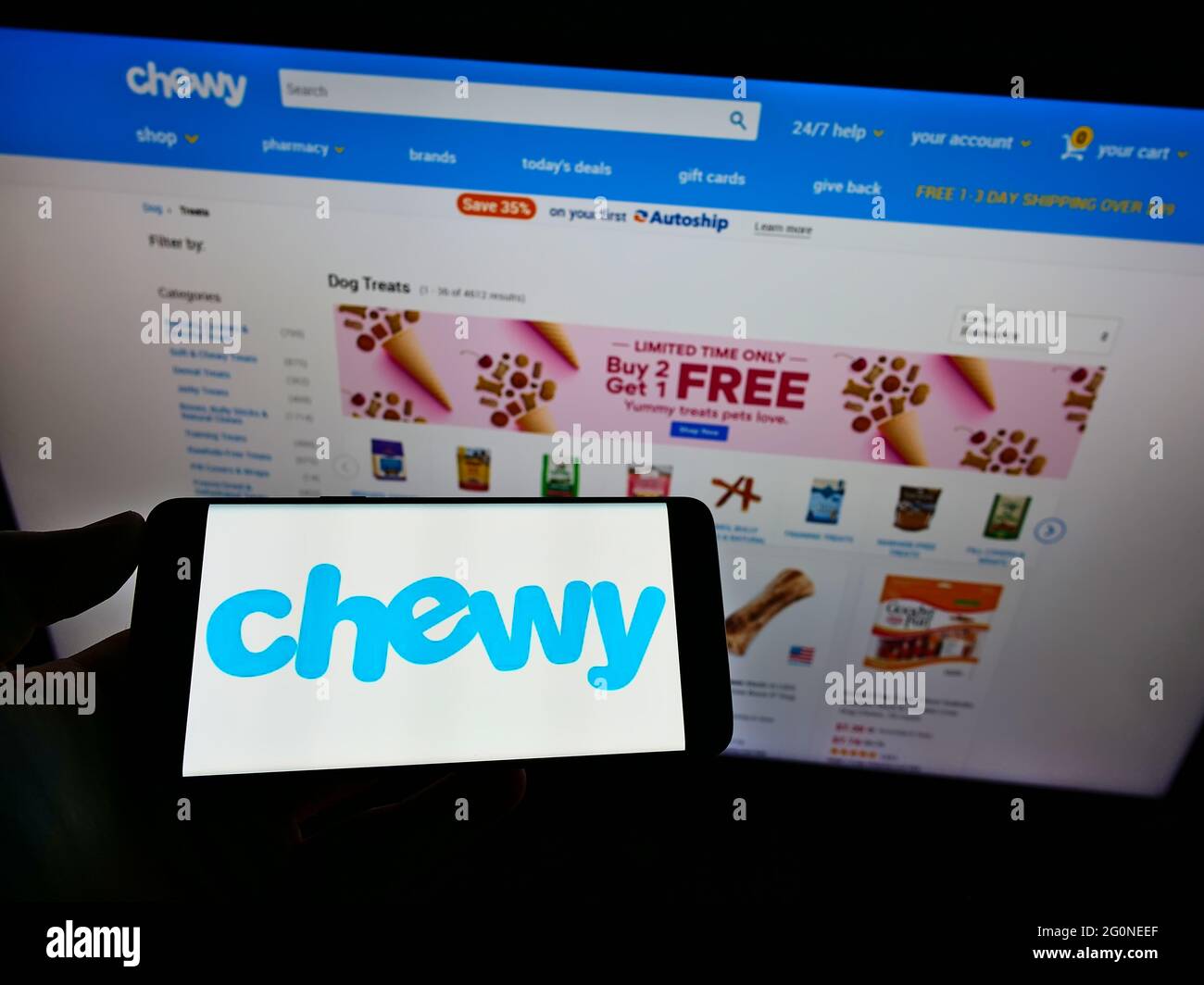 Person, die Mobiltelefon mit dem Logo des US-amerikanischen Heimtiernahrung-Online-Einzelhandelsunternehmens Chewy Inc. Auf dem Bildschirm vor der Unternehmenswebseite hält. Konzentrieren Sie sich auf die Telefonanzeige. Stockfoto