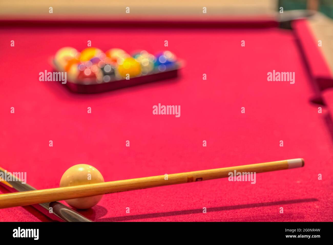 Roter Billardtisch mit Kugeln und Queuesticks Stockfoto