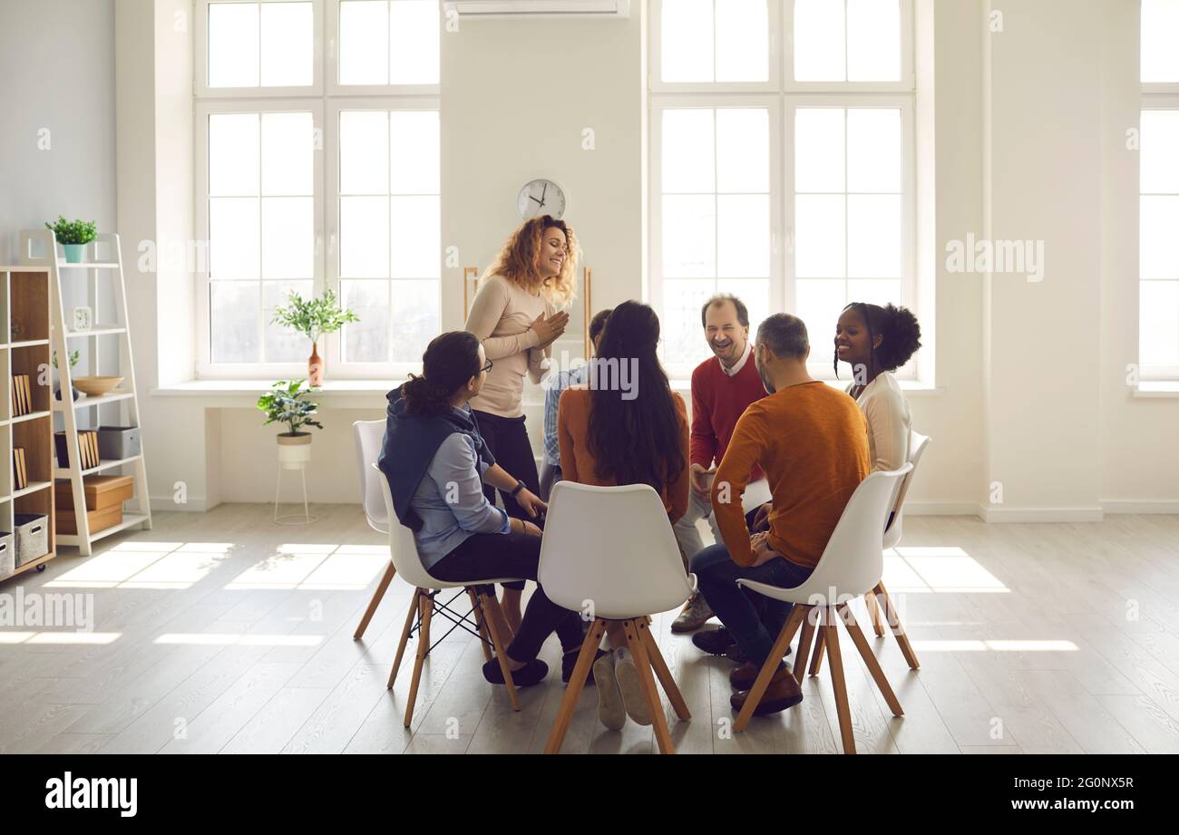 Personen, die an einer Gruppentherapie zur Ausbildung sozialer Fähigkeiten im hellen Büro teilnehmen Stockfoto