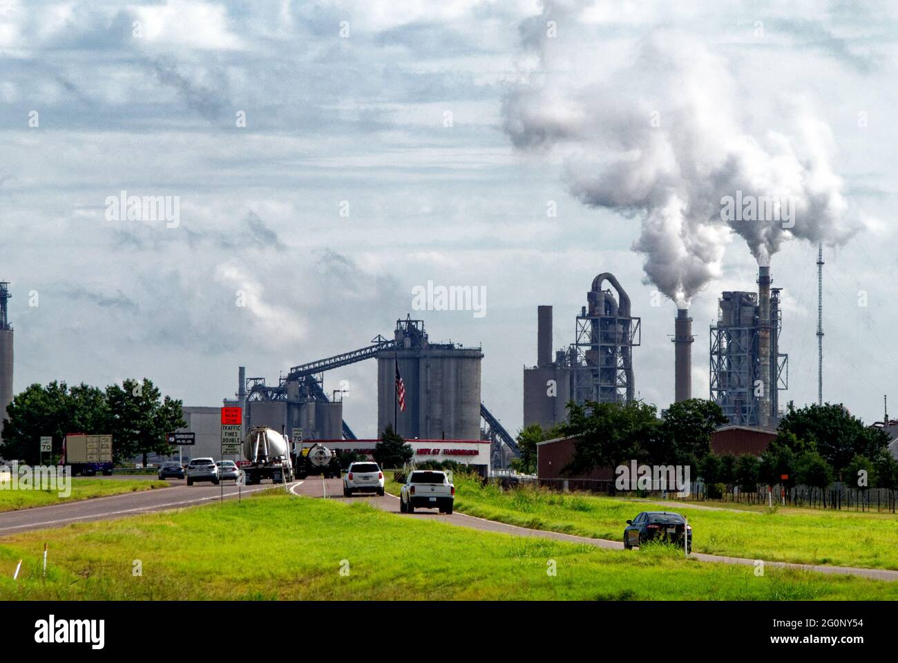 Der Ofen der Midlotian-Zementanlage im Holcum-Werk südwestlich von Dallas ist einer der größten CO2-Schadstoffe. Wenn Städte wachsen, brauchen sie Zement und machen die Zementindustrie zu einem der größten Verschmutzer der Welt. Drei Werke entlang der Autobahn haben Midlothian den Namen „Betongasse“ gegeben, die Stadt ist die offizielle „Betonstadt von Texas“. Stockfoto