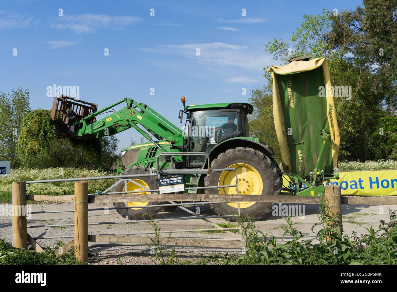 JOHN DEERE Traktor, schneidet Gräser und Unkraut auf dem Land, Kent, England Stockfoto