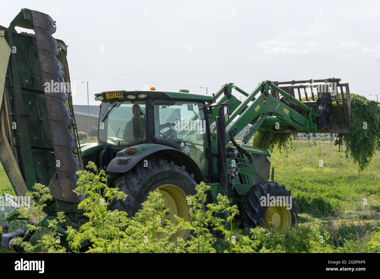 JOHN DEERE Traktor, schneidet Gräser und Unkraut auf dem Land, Kent, England Stockfoto