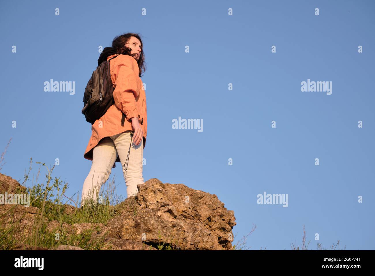 Das Mädchen klettert auf einen felsigen Berg. Reisen Sie allein außerhalb der Stadt. Stockfoto