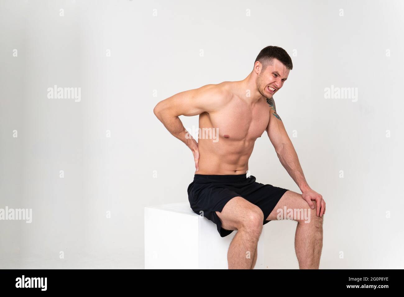 Ein Mann Rückenschmerzen hält seine Hand auf seinem Rücken Schmerzen Muskelschmerzen, Rückenschmerzen weißen Gesundheitsstress, menschlichen Ausdruck. Spannung rote Therapie, Rücken leiden attr Stockfoto