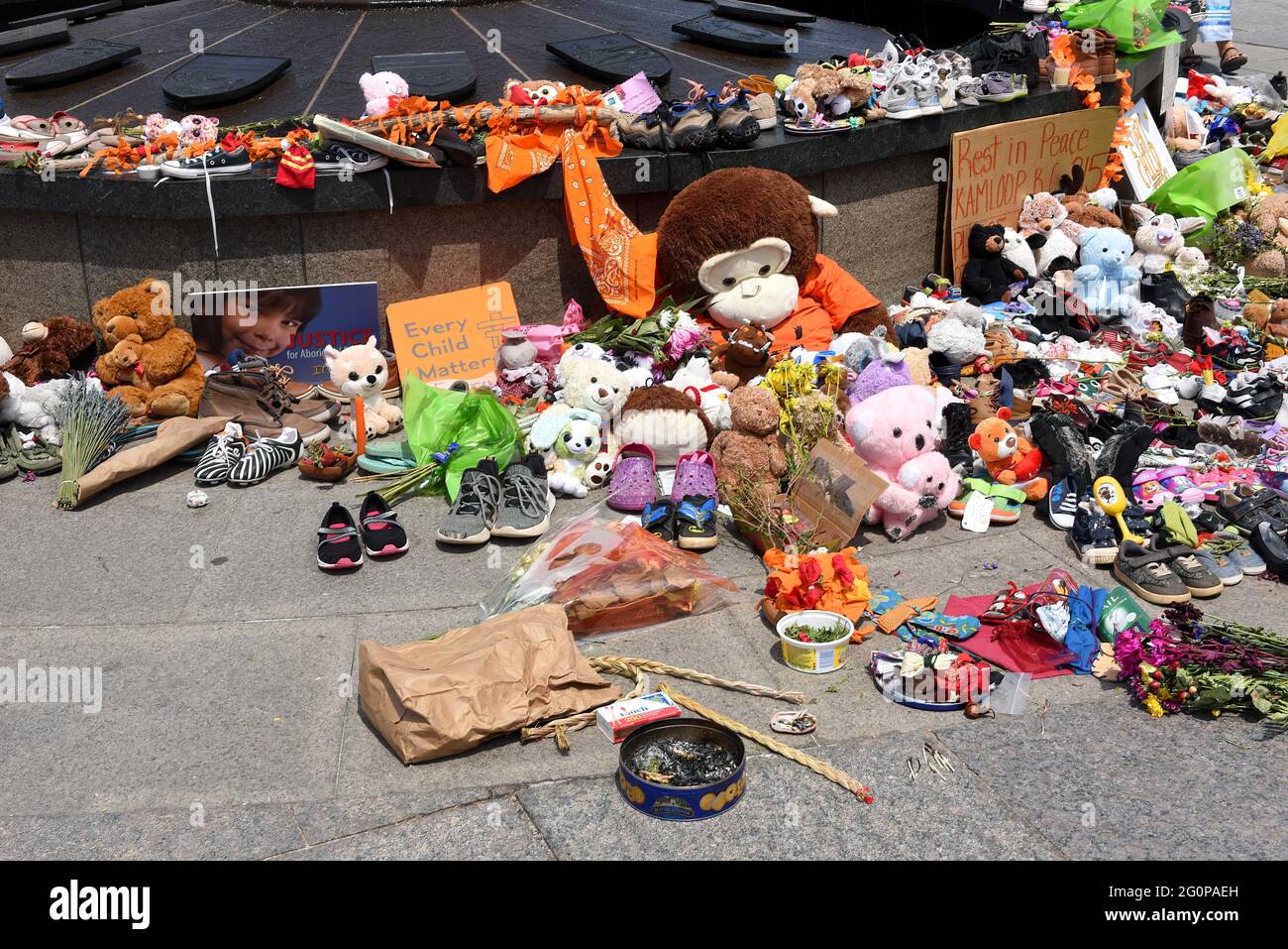 Ottawa, Kanada - 2. Juni 2021: Einige der vielen Schuhe und Spielzeuge, die in der Nähe der Centennial Flame auf dem Parliament Hill in Erinnerung an die 215 Kinder zurückgelassen wurden, deren Überreste in der Nähe einer ehemaligen Wohnschule in Kamloops, B.C. gefunden wurden. Stockfoto