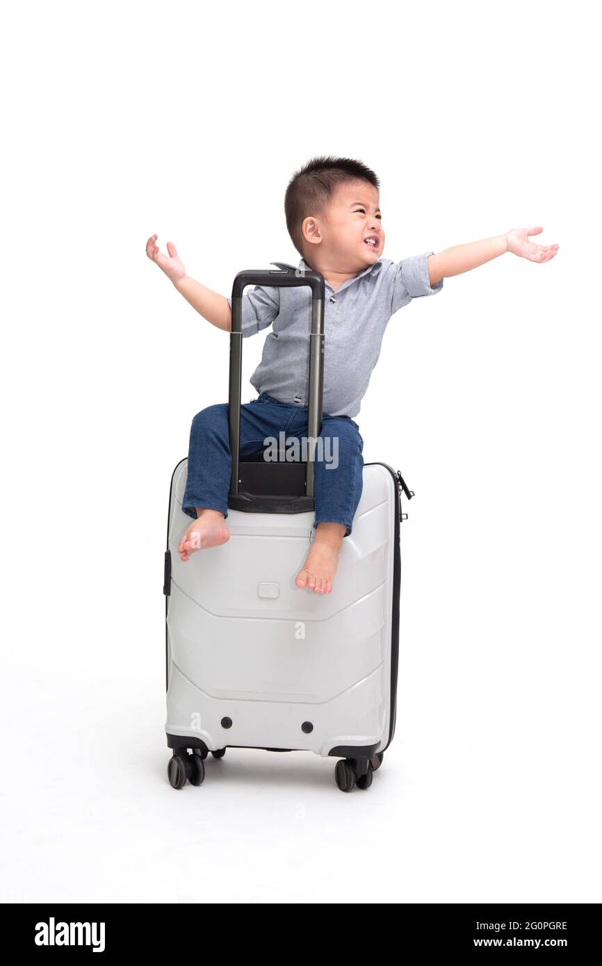 Asiatische baby boy sitting Reisetasche oder Koffer auf weißem Hintergrund, Reisen und neue Abenteuer Familie Reise für Kind Passagier Konzept, Eins Stockfoto