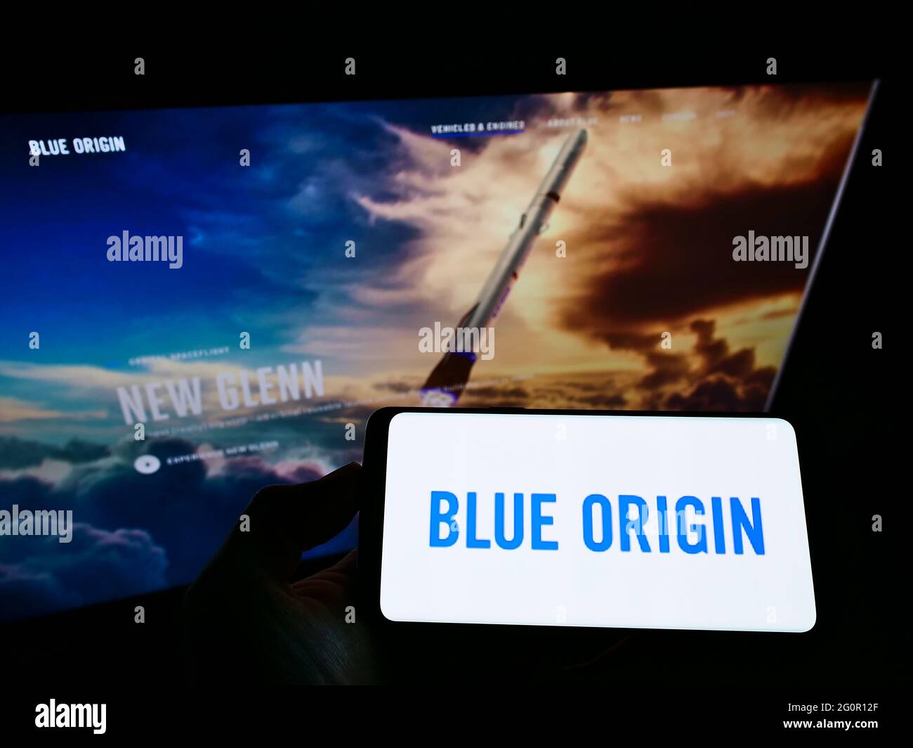 Person, die Smartphone mit dem Logo des US-Luftfahrtunternehmens Blue Origin LLC auf dem Bildschirm vor der Website hält. Konzentrieren Sie sich auf die Telefonanzeige. Stockfoto