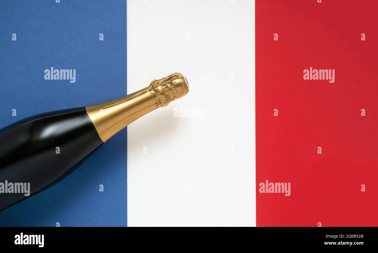 Französische Champagnerflasche und französische Nationalflagge, Blick von oben, Konzept für den Bastille-Tag und den französischen Nationalfeiertag Stockfoto