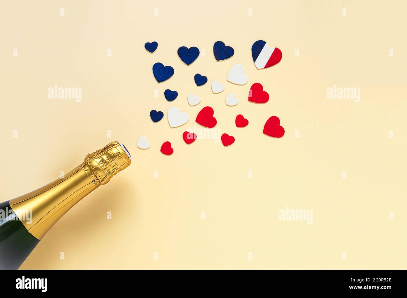 Herzen in den Farben der französischen Flagge und einer französischen Champagnerflasche, Blick von oben, Bastille Day und Konzept des französischen Nationaltages Stockfoto