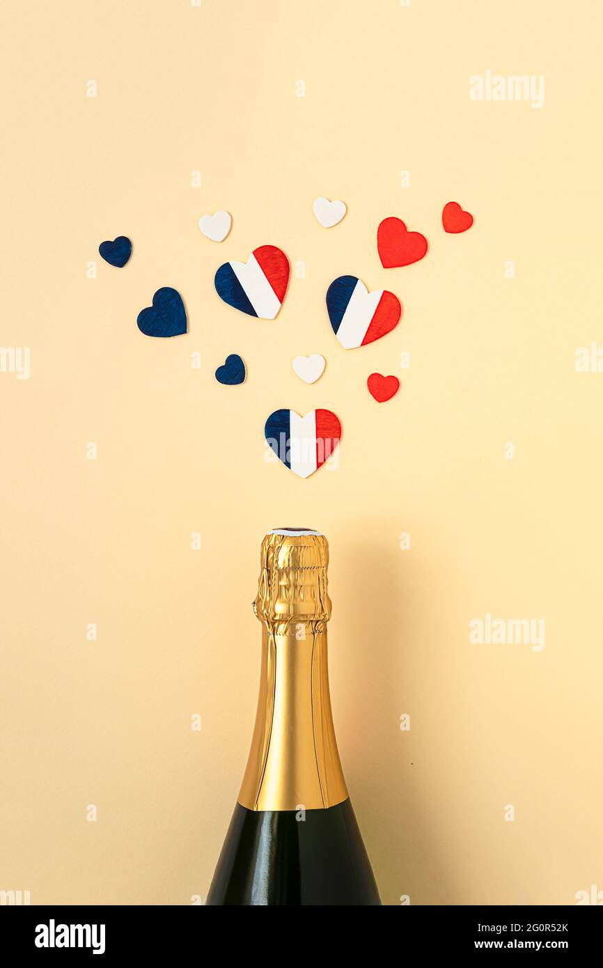 Französische Champagner-Flasche und Herzen in den Farben der französischen Flagge, Blick von oben, Bastille-Tag und Konzept des französischen Nationaltages Stockfoto