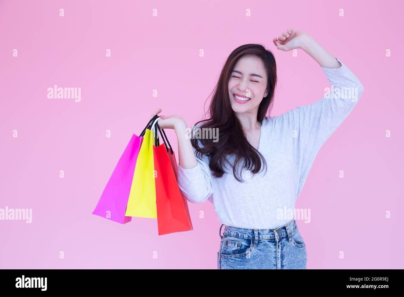 Gerne schöne asiatische Frauen genießen Sie Shopping auf rosa Hintergrund, Shopaholic, während der Förderung oder Angebot Preis in Valentines Tag kaufen, Konsum Stockfoto
