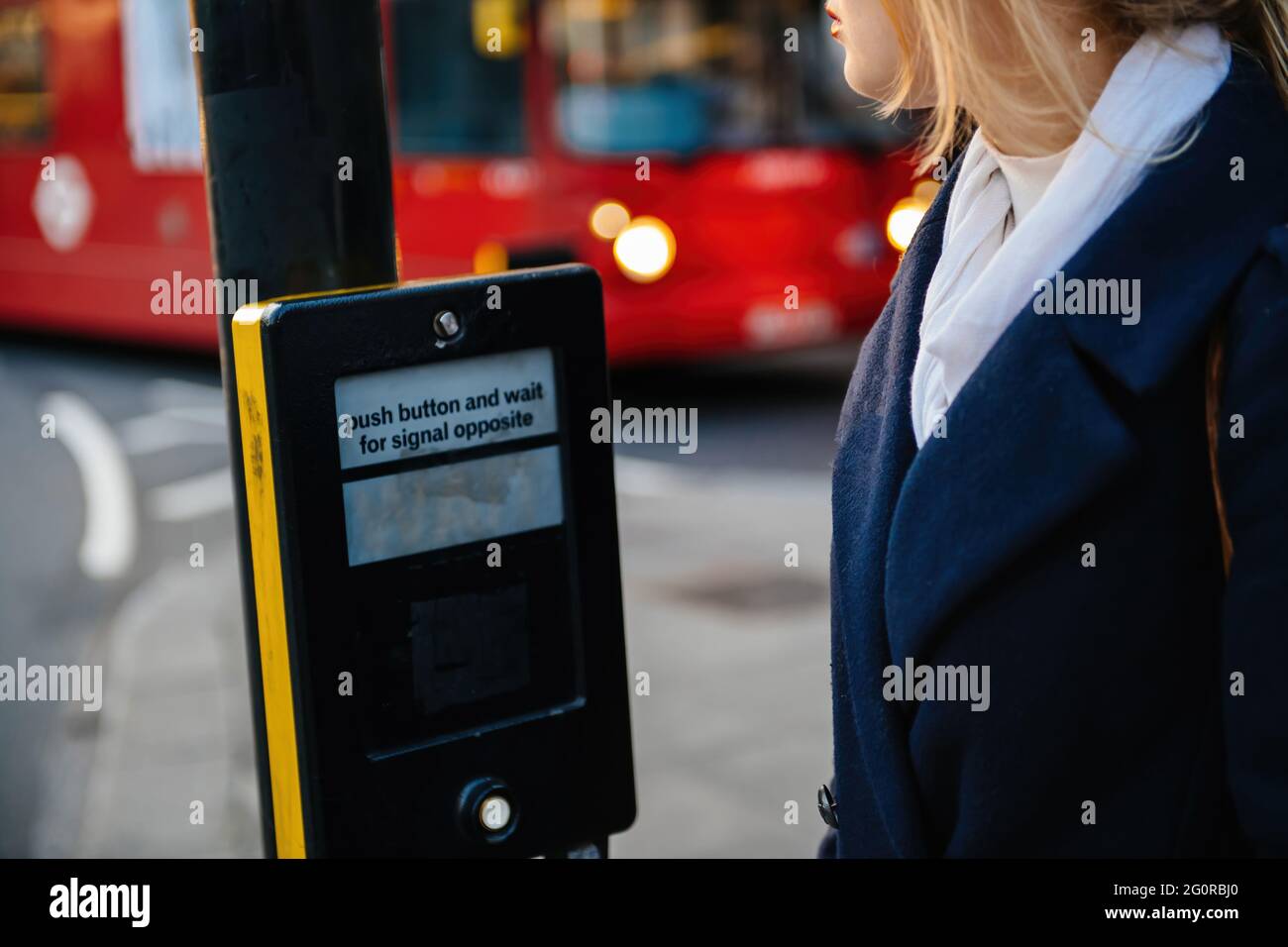 Schöne Frau im Druckknopf und warten auf Signal gegenüber Kreuzung in London Stockfoto