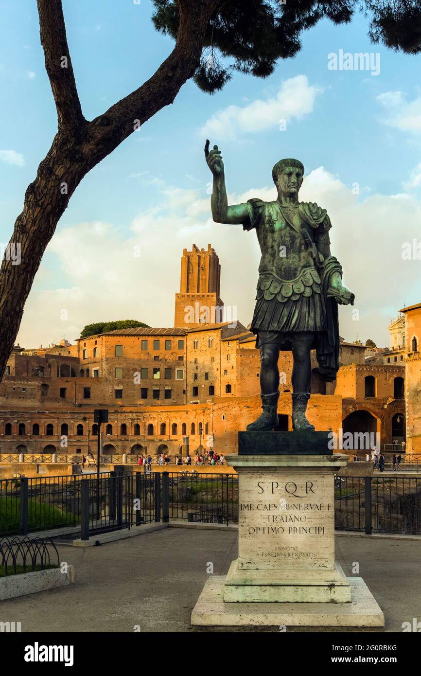 Rom, Italien. Statue des Imperators Trajan mit dem Forum von Trajan dahinter. Das Forum stammt aus dem zweiten Jahrhundert nach Christus. Der Turm in der Mitte ist der 13 Stockfoto