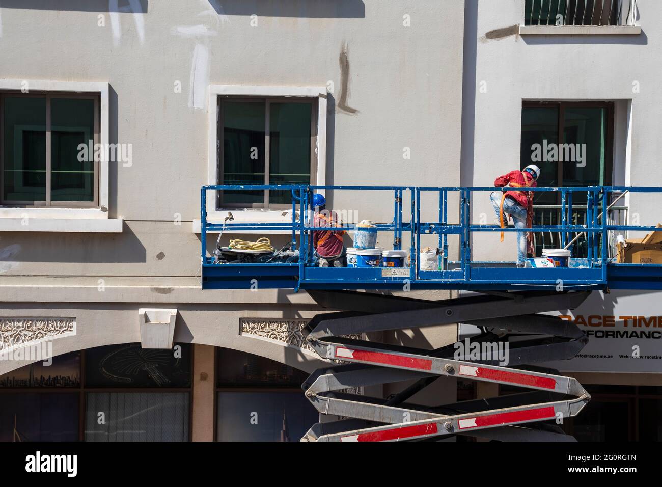 Aufnahme eines in der Höhe arbeitenden Wartungspersonal, das die Fassade des Gebäudes repariert Stockfoto