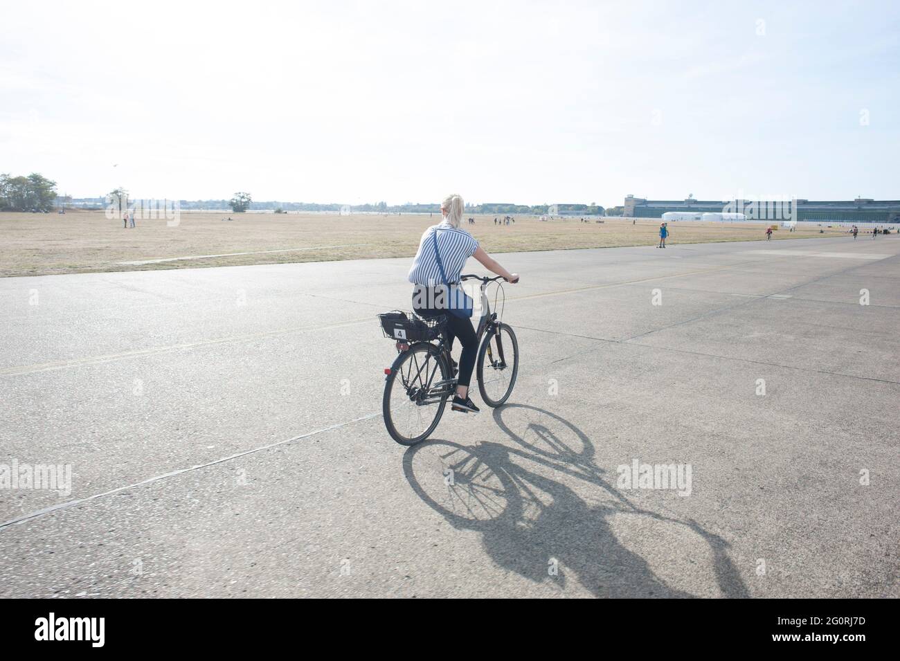 Touristen besuchen den Berliner Flughafen Tempelhof und erkunden ihn mit dem Fahrrad Stockfoto