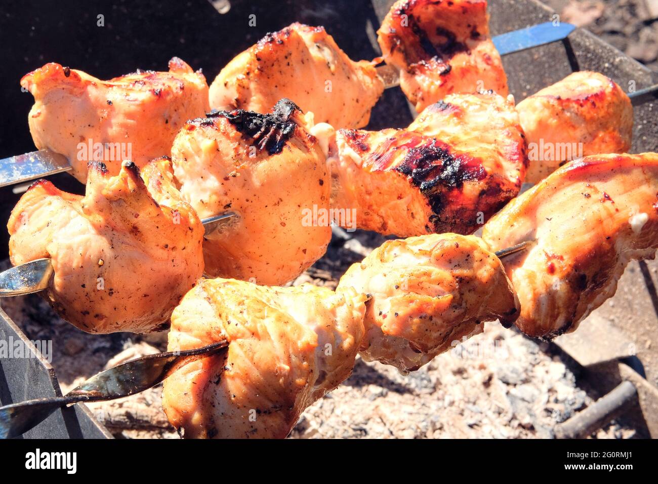 Fleisch braten auf dem Grill. Gebratene Schweinefleisch- und Rinderspieße auf Kohlen im Freien. Grillfleisch Hintergrund. Stockfoto