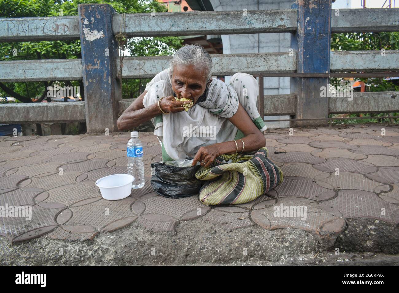 Kalkutta, Indien. Juni 2021. Eine obdachlose alte Frau isst während einer Sperrzeit in Kalkutta auf einer Straße Essen.das Land meldete am Donnerstag 134,154 neue kovidierte Fälle und 2,887 Todesfälle. Nach Angaben des Gesundheitsministeriums wurden in den letzten 24 Stunden insgesamt 211,499 Patienten entlassen. (Foto von Sudipta das/Pacific Press) Quelle: Pacific Press Media Production Corp./Alamy Live News Stockfoto