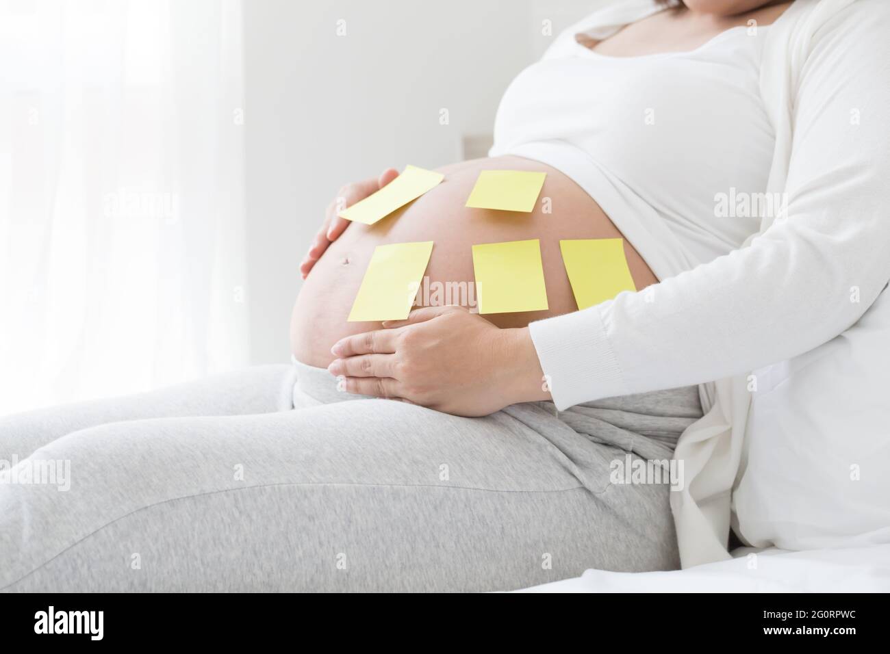 Wählen Sie während der Schwangerschaft einen Babynamen aus und geben Sie diesen an Stockfoto