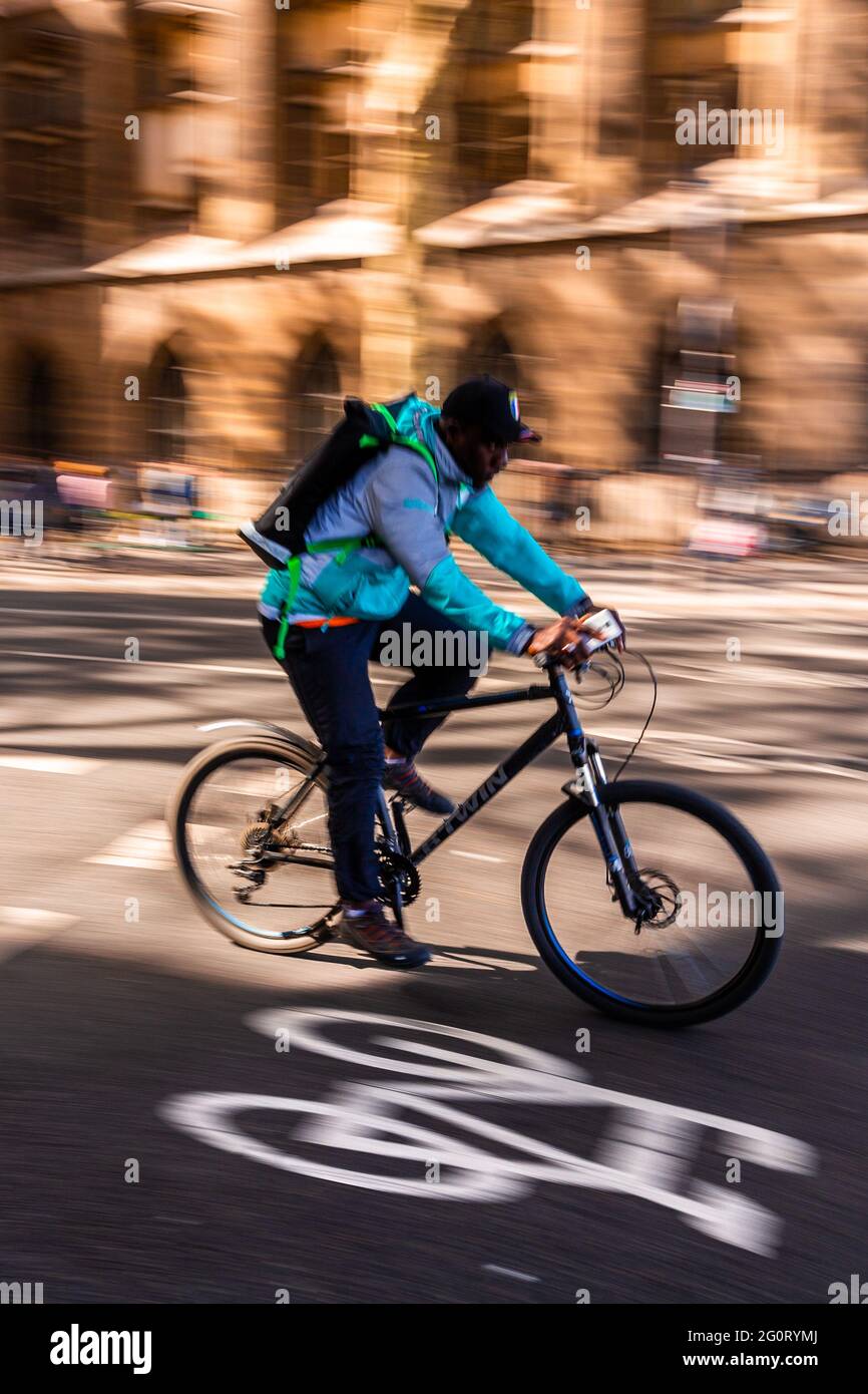 Paris, Frankreich - 29. September 2018 : verschwommene Bewegungsszene eines französischen Mannes in blauem Hemd, der ein schwarzes Fahrrad mit Geschwindigkeit über die Fahrradspur auf der Straße radelt Stockfoto