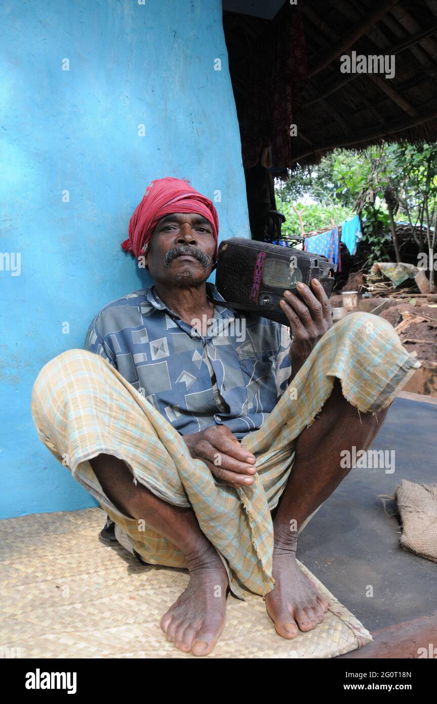 Ein Dorfbewohner in Koraput, Odisha, Indien, hört sich einen neu eingerichteten Community Radio Sender an, der in ihrer eigenen Sprache und ihrem eigenen Wortschatz über sie spricht. Stockfoto