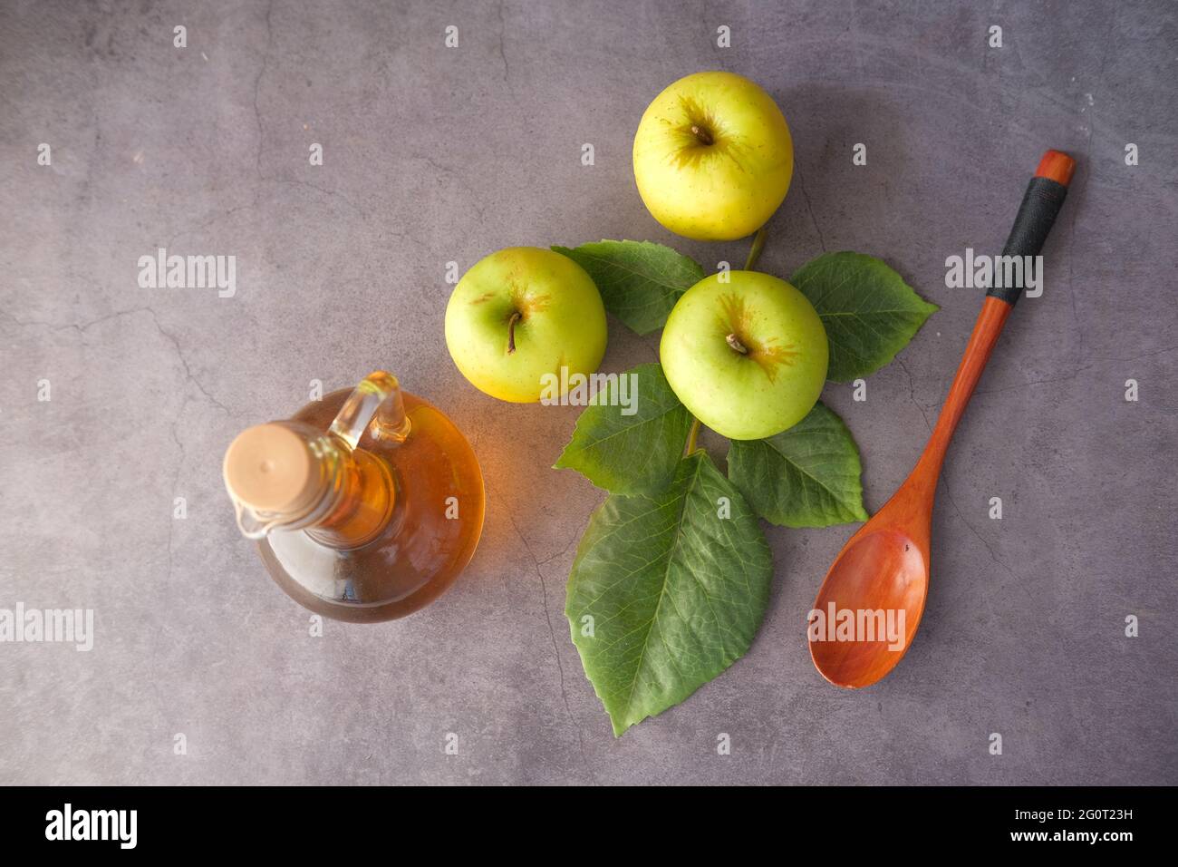 apfelessig in der Flasche und grüner Apfel auf dem Tisch Stockfoto