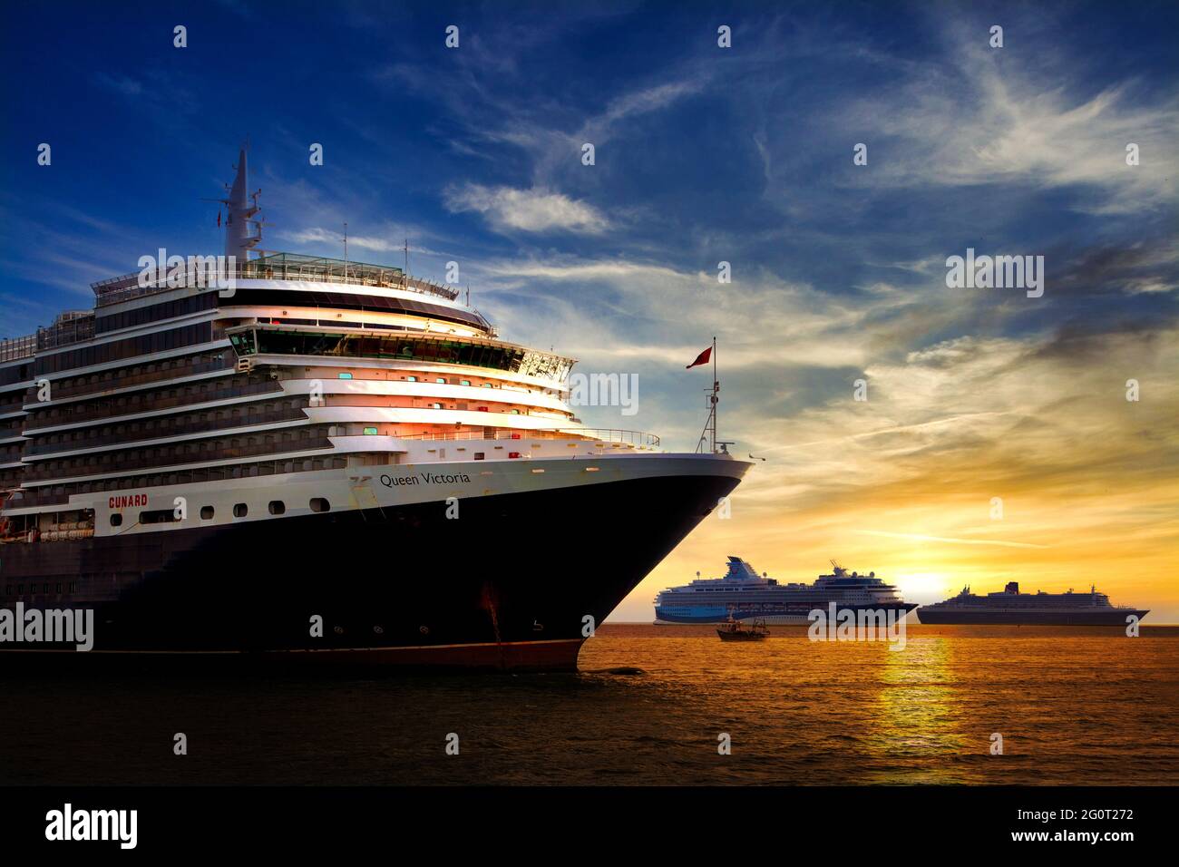 Das Queen Victoria-Schiff genießt einen farbenfrohen Sonnenaufgang neben der Marella Explorer und Queen Mary 2 (rechts). Stockfoto