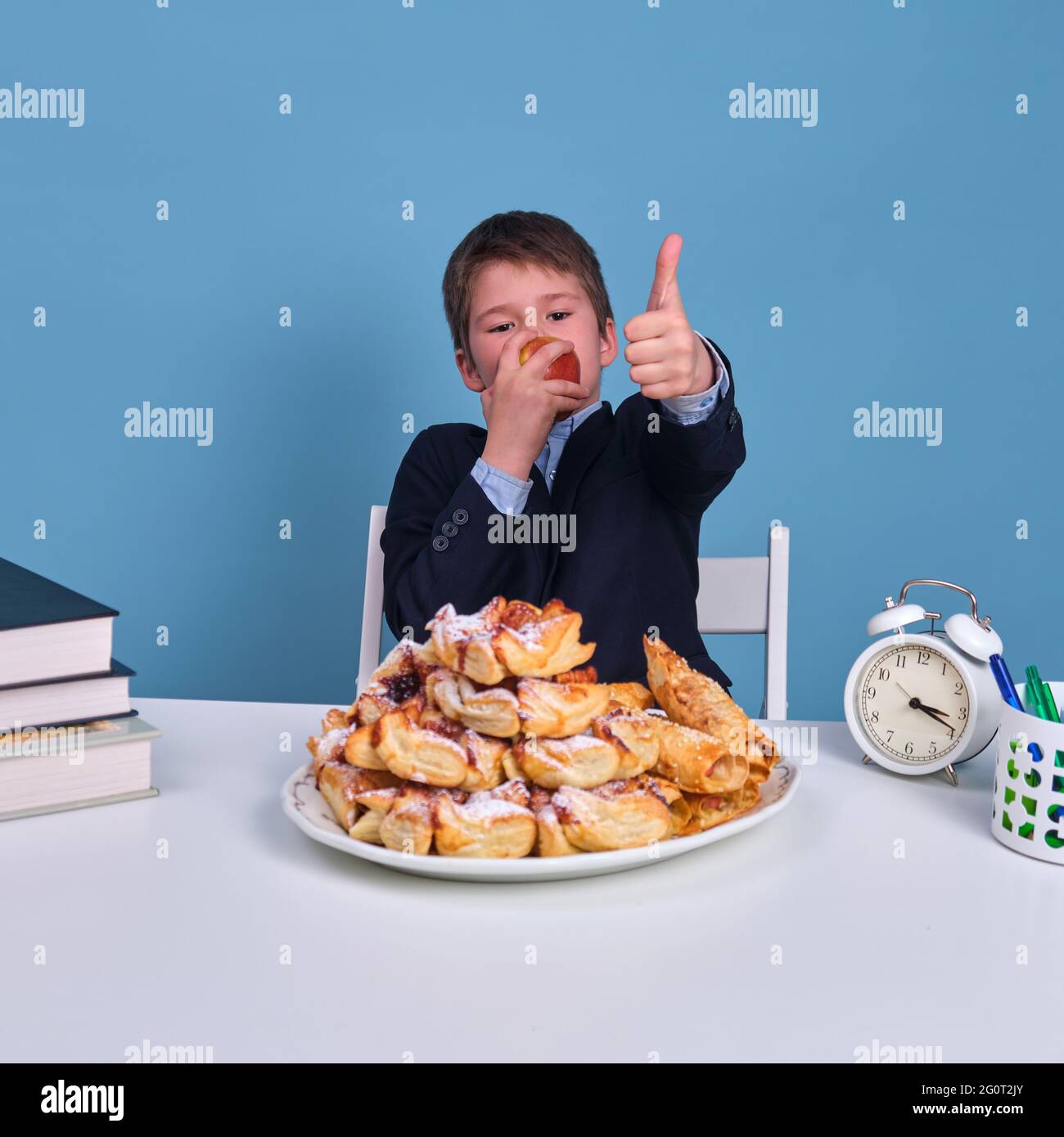 Schüler Junge Junior mit einem Apfel in den Händen zeigt eine Geste der Zustimmung zu gesunden und gesunden Lebensmitteln Stockfoto