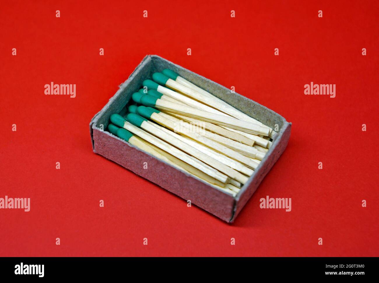 Holzmatches in Pappkarton auf rotem Hintergrund Stockfoto