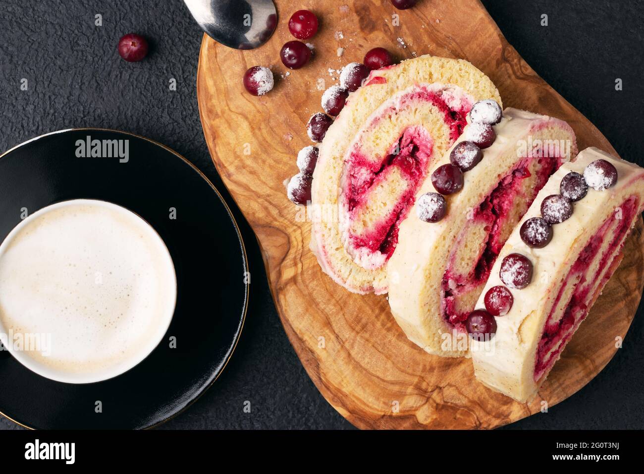 Hausgemachte Biskuit süße Rolle mit Preiselbeeren und Sahne auf einem  schwarzen Tisch, Draufsicht, flach legen Stockfotografie - Alamy