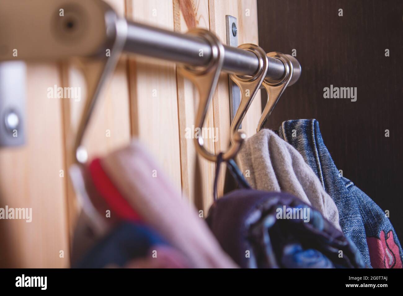 Kleiderbügel für Kinder an Metallhaken. Nahaufnahme. Stockfoto