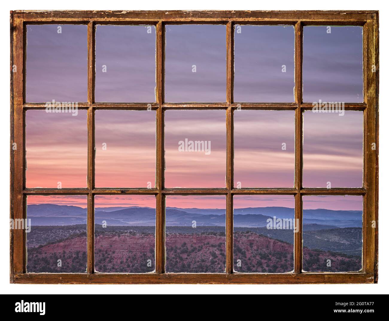 Farbenprächtiger Himmel bei Sonnenaufgang im Nordwesten Colorados, von einem alten Kabinenfenster aus gesehen Stockfoto